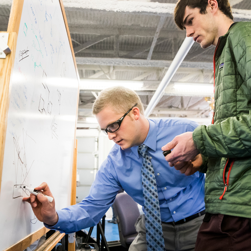 boys writing on whiteboard